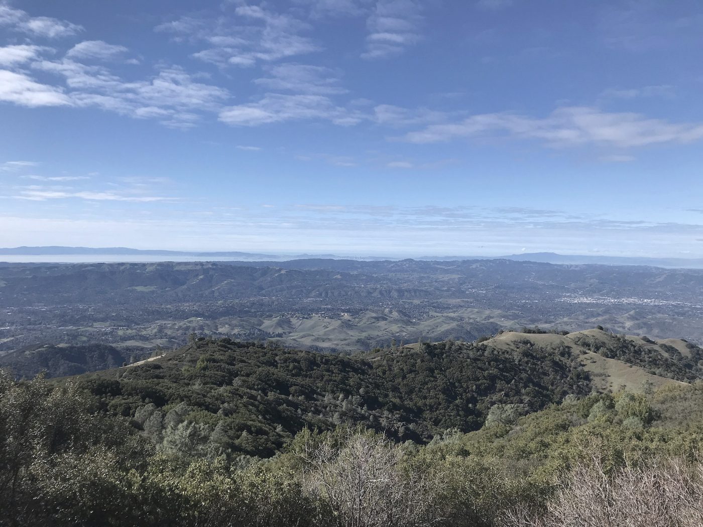 Wooded ridges above a broad valley, with distant hills under a wide sky